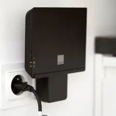 Czarny router Orange Funbox 6 podłączony do gniazdka.