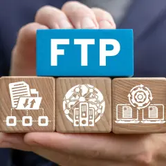 Klocki z ikonami symbolizującymi transfer danych i serwery, z napisem FTP.