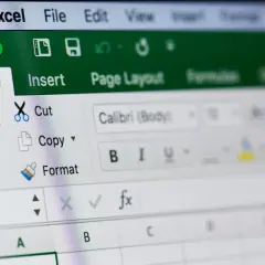 Ekran Excel z opcjami "Home", "Insert", "Cut", "Copy", "Paste", "Format". Widoczne pole formuły fx. Blokowanie komórek Excel jest kluczowe.