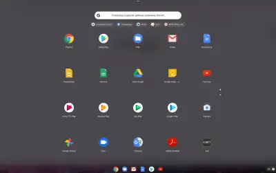 Ekran startowy systemu ChromeOS z ikonami aplikacji: Chrome, Sklep Play, Pliki, Gmail, Dokumenty, Prezentacje, Arkusze, Dysk Google, YouTube, Filmy i TV Play, Muzyka Play, Gry Play, Książki Play, Kamera, Google Photos, Duo, Tłumacz, Adobe Acrobat, Text.