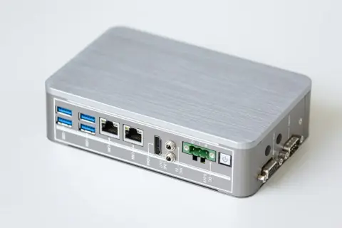 Srebrna, kompaktowa obudowa z licznymi portami: USB, LAN, HDMI, audio, zasilanie DC, COM i VGA. Idealne rozwiązanie do zastosowań sieciowych, np. jako router z funkcją CGNAT.