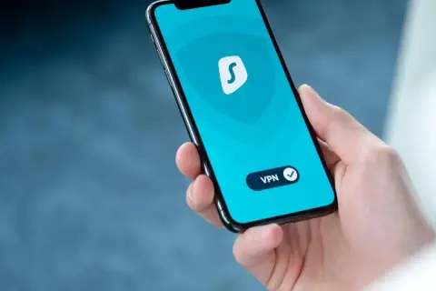 Dłoń trzyma smartfon z włączoną aplikacją VPN. To pokazuje, co to jest VPN w telefonie i jak chroni Twoją prywatność online.
