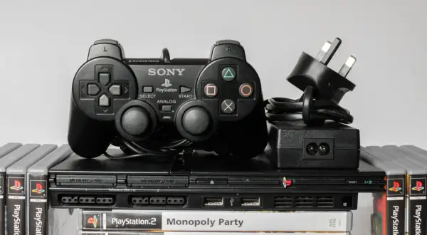 Konsola PlayStation 2 z kontrolerem DualShock 2, zasilaczem i grami. Klasyczny emulator PS2, gotowy do akcji.