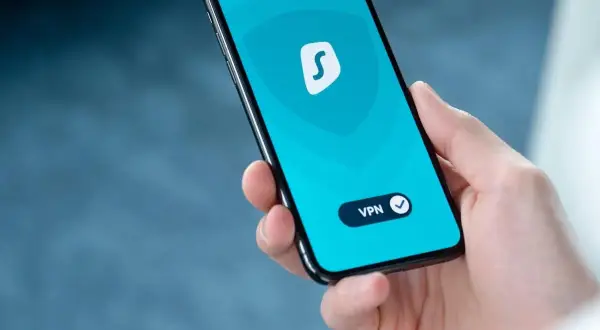 Dłoń trzyma smartfon z włączoną aplikacją VPN. To pokazuje, co to jest VPN w telefonie i jak chroni Twoją prywatność online.