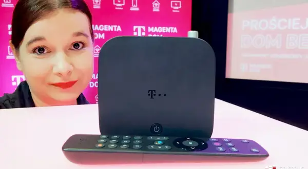 Kobieta prezentuje dekoder i pilot do telewizji T-Mobile Magenta Dom.