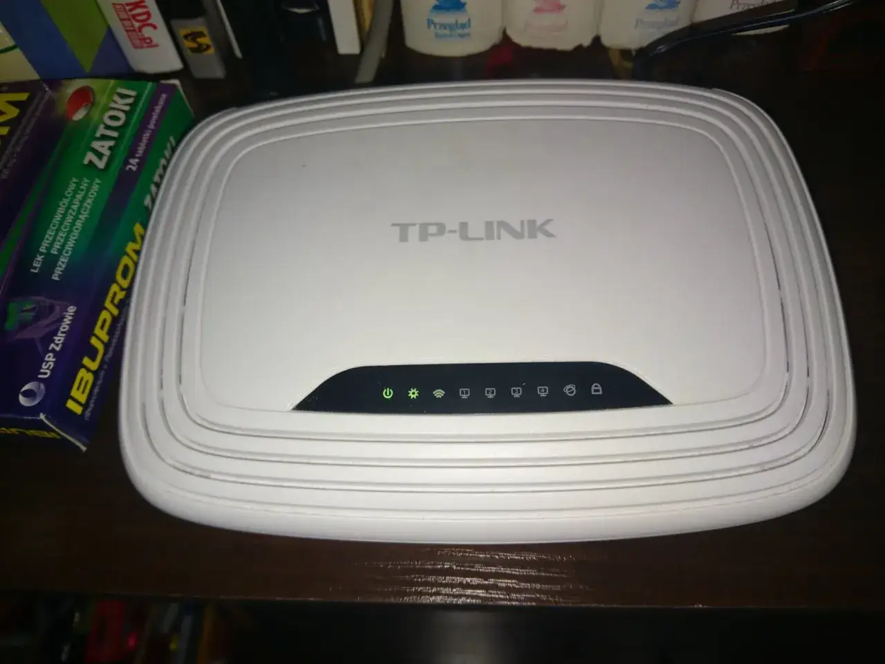 Router TP-Link z migającymi diodami sygnalizuje multimedia awaria dzisiaj. Obok leki na zatoki.