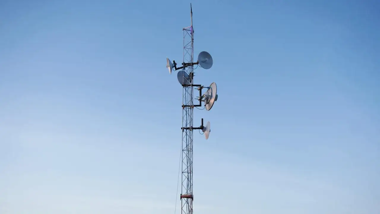 Wieża telekomunikacyjna z antenami parabolicznymi, zapewniająca internet radiowy w okolicy.