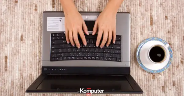 Dłonie piszą na klawiaturze laptopa, obok filiżanka kawy. Stary speccy wciąż działa!